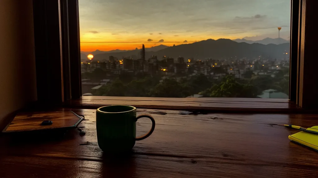 Vista nocturna de Bucaramanga desde la ventana de una oficina en casa con un portátil.